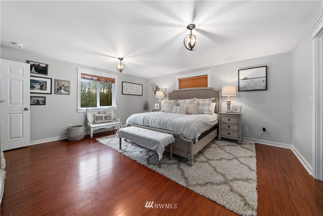 14817 South Tilley Road Tenino, WA 98589 - Photo 17 of 38 a spacious bedroom with a bed a couch and a window