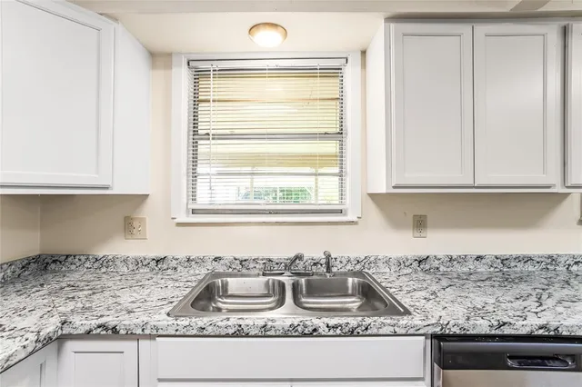 a kitchen with granite countertop a sink and a stove