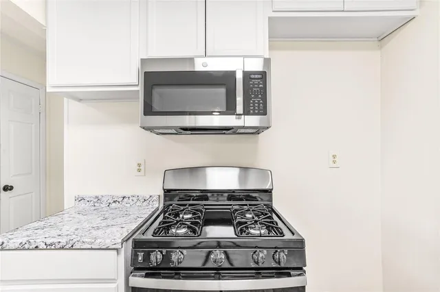 a stove top oven sitting inside of a kitchen