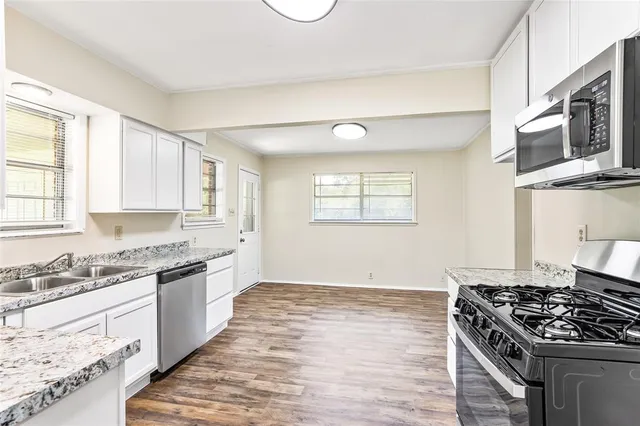 a kitchen with stainless steel appliances granite countertop a stove and a microwave