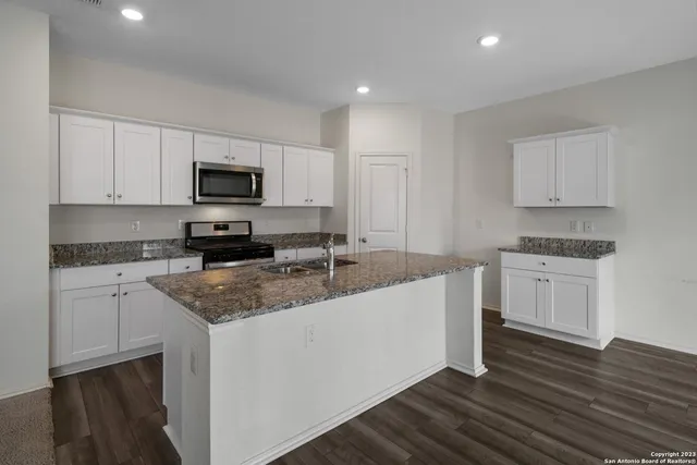a kitchen with appliances a sink and cabinets