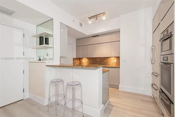 a kitchen with stainless steel appliances granite countertop a refrigerator and a stove top oven
