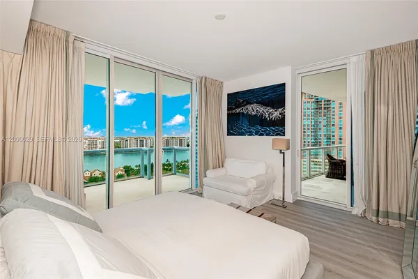 a bedroom with a balcony a bed and a large window