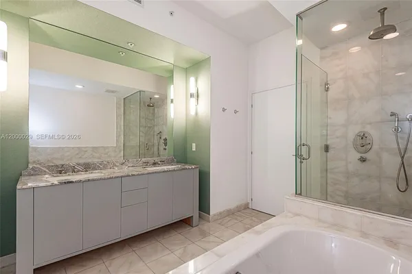 a bathroom with a granite countertop sink a mirror and a shower
