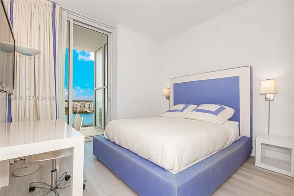 a bedroom with a large bed and a large window with outer view