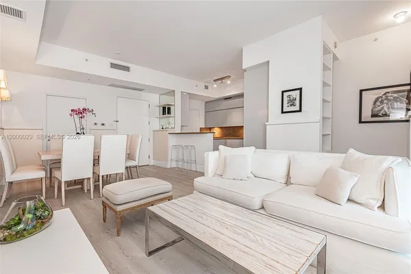 a living room with furniture and kitchen view