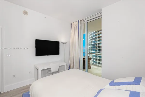 a bedroom with a bed and a flat screen tv