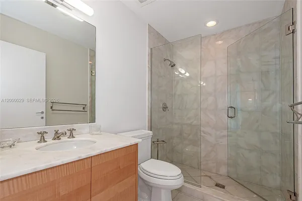 a bathroom with a sink toilet double vanity and shower