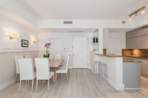 a kitchen with stainless steel appliances a dining table chairs and wooden floor