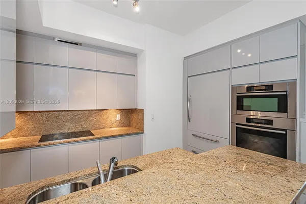 a kitchen with a refrigerator and a stove top oven