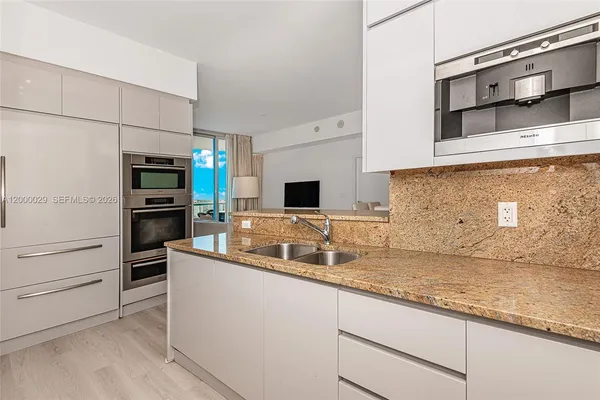 a kitchen with stainless steel appliances granite countertop a sink and a stove top oven
