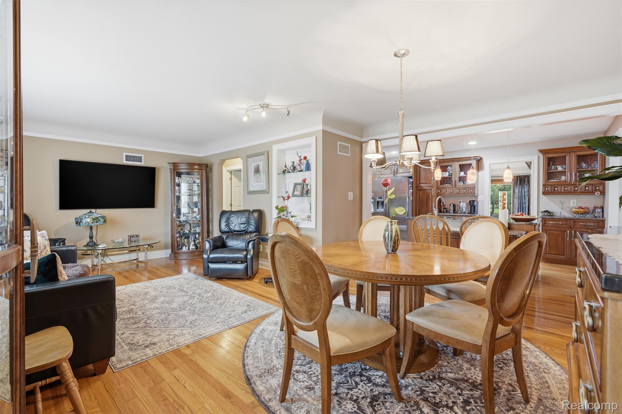 Dining area with light wood finished floors and ornamental molding