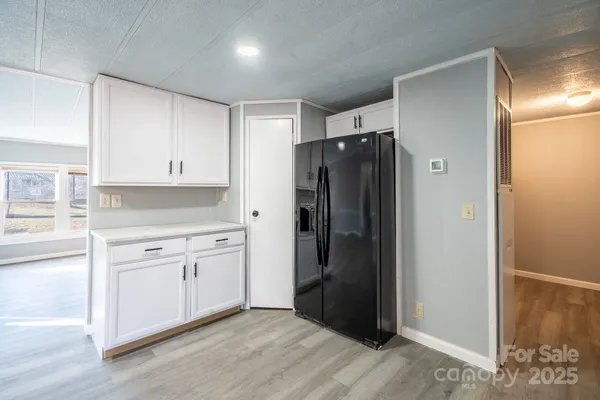 a kitchen with refrigerator a sink and white cabinets