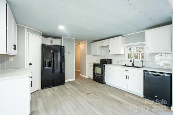 a kitchen with granite countertop a refrigerator stove top oven and sink