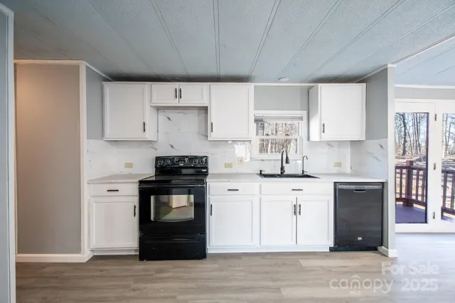 a view of a kitchen counter space a sink and wooden floor