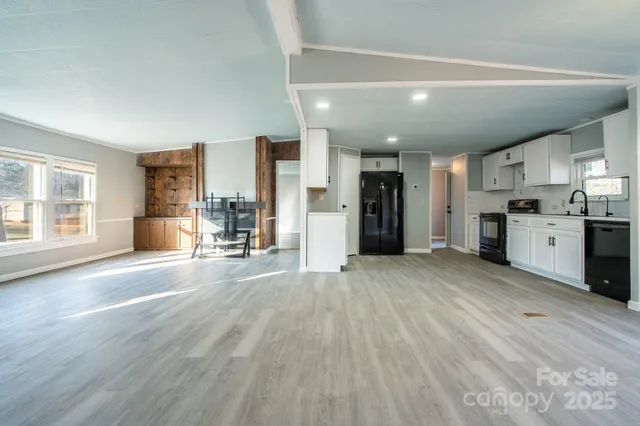 a view of empty room with wooden floor and furniture