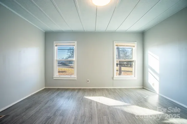a view of an empty room with wooden floor