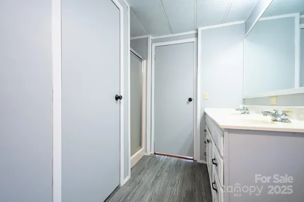 a bathroom with a granite countertop sink toilet mirror and bathtub