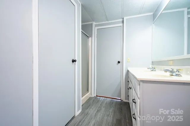 a bathroom with a granite countertop sink toilet mirror and bathtub