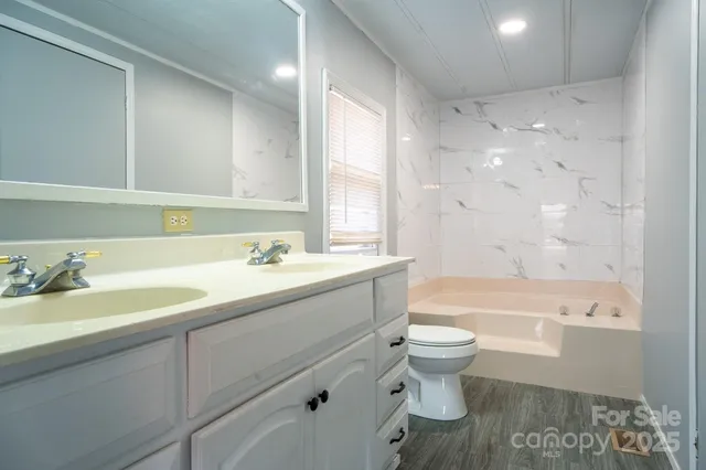 a bathroom with a bathtub toilet and window