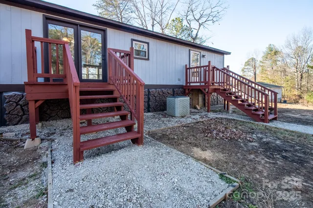 a view of a house with a yard and wooden deck