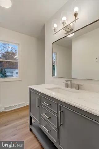 a bathroom with a granite countertop sink a mirror and vanity