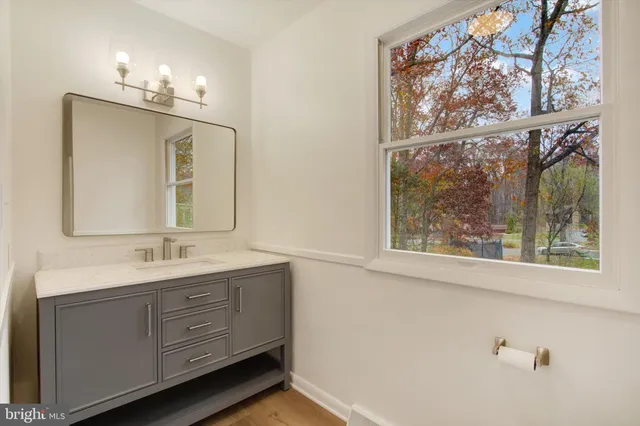 a bathroom with a double vanity sink a mirror and a window