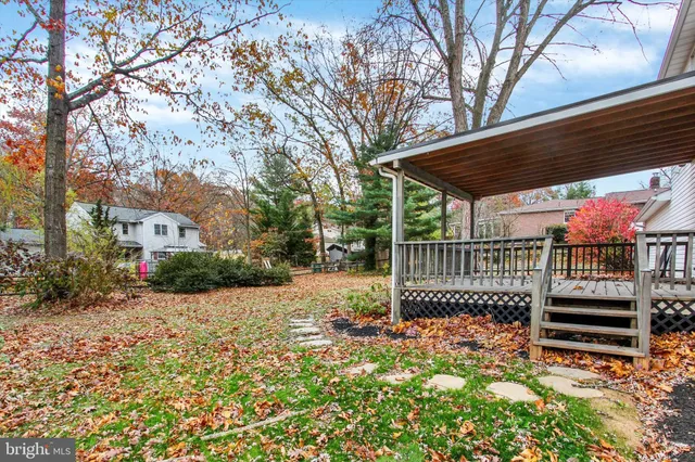 a view of a backyard with wooden fence and a bench