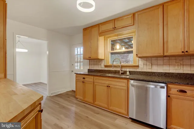 a kitchen with granite countertop cabinets stainless steel appliances a sink and a window