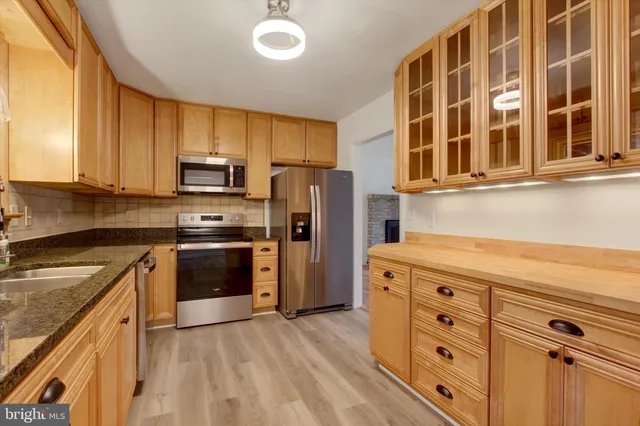 a kitchen with stainless steel appliances granite countertop a stove and a refrigerator
