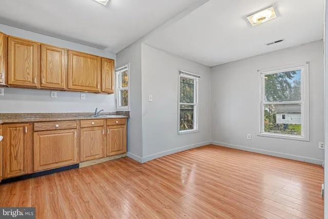 a view of a kitchen with wooden floor and a window