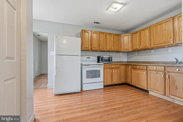 a kitchen with white cabinets and white appliances