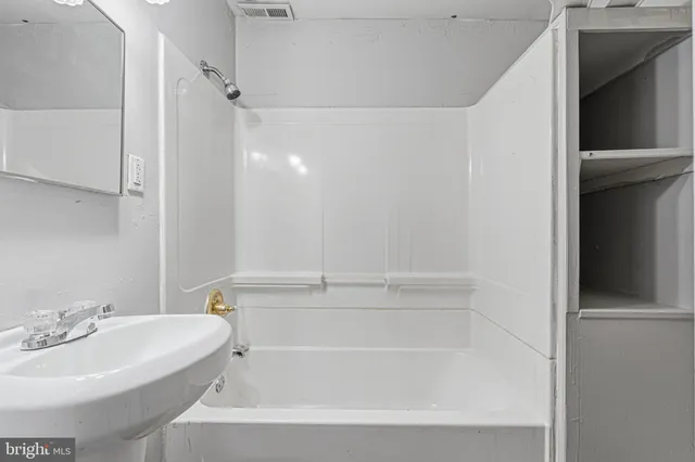a white bath tub sitting next to a white sink