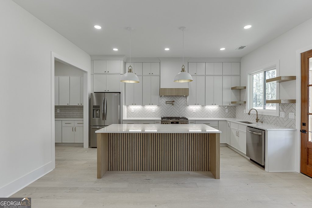 5422 Copper Crk Road Flowery Branch, GA 30542 - Photo 12 of 57 a kitchen with stainless steel appliances a sink stove refrigerator and cabinets