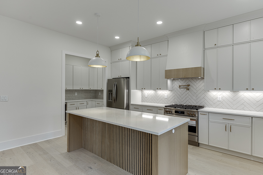 5422 Copper Crk Road Flowery Branch, GA 30542 - Photo 15 of 57 a kitchen with kitchen island a sink stainless steel appliances and cabinets