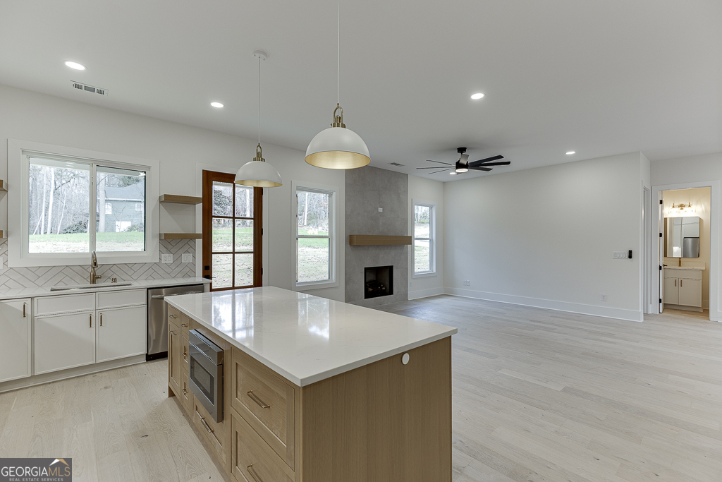 5422 Copper Crk Road Flowery Branch, GA 30542 - Photo 17 of 57 an open kitchen with granite countertop a sink and dishwasher a oven with white cabinets