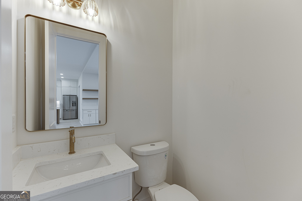 5422 Copper Crk Road Flowery Branch, GA 30542 - Photo 22 of 57 a bathroom with a toilet sink and mirror