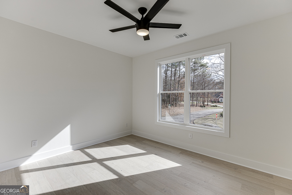 5422 Copper Crk Road Flowery Branch, GA 30542 - Photo 27 of 57 a view of wooden floor and a chandelier fan in a room