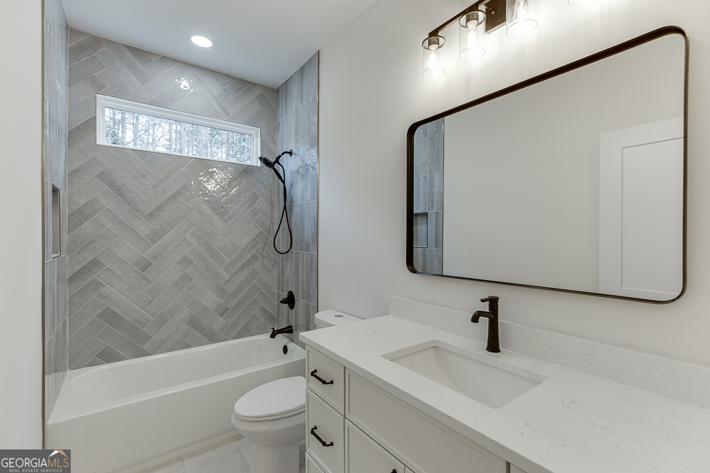 5422 Copper Crk Road Flowery Branch, GA 30542 - Photo 34 of 57 a bathroom with a granite countertop sink a toilet and a bathtub