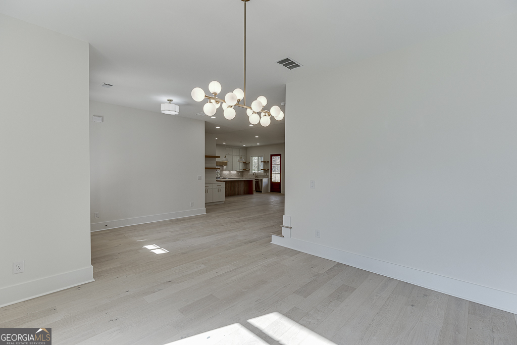 5422 Copper Crk Road Flowery Branch, GA 30542 - Photo 6 of 57 a view of a chandelier in big room with wooden floor and a chandelier