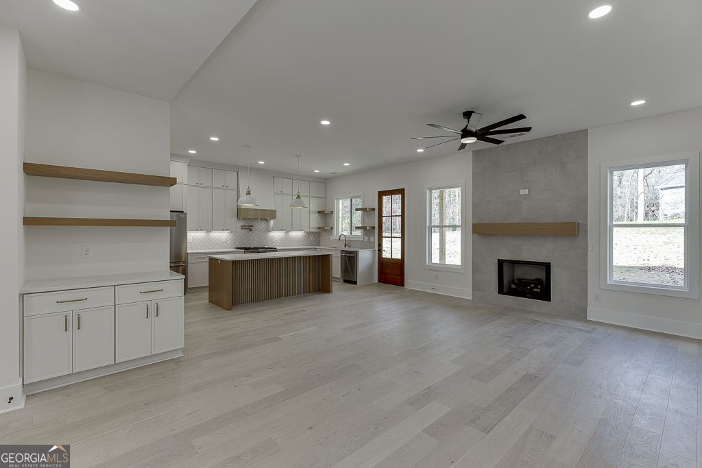 5422 Copper Crk Road Flowery Branch, GA 30542 - Photo 8 of 57 a view of a kitchen with a sink a fireplace and a window