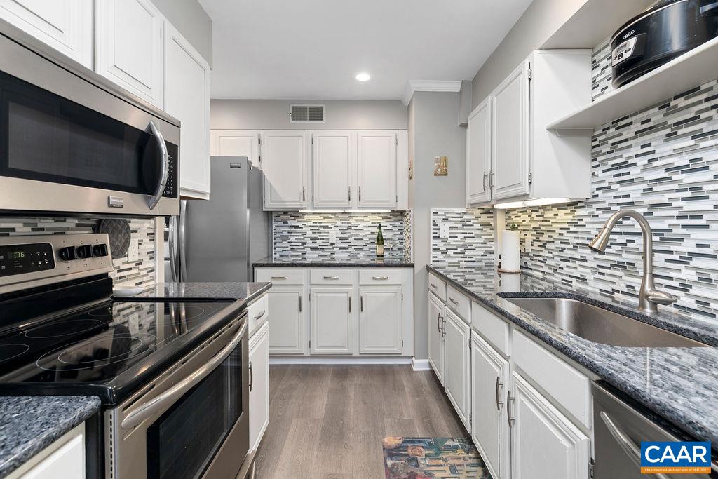 2070 Stone Ridge Wintergreen, VA 22967 - Photo 2 of 52 a kitchen with stainless steel appliances kitchen island granite countertop a sink dishwasher stove and microwave with wooden cabinets