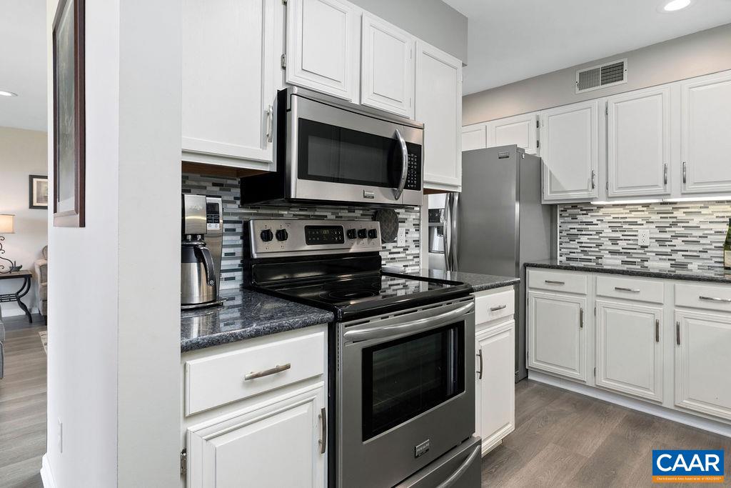 2070 Stone Ridge Wintergreen, VA 22967 - Photo 10 of 52 a kitchen with stainless steel appliances white cabinets a stove a microwave and a refrigerator