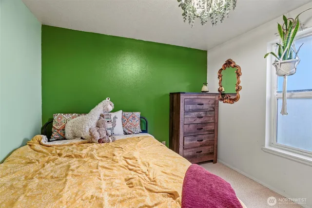 a bedroom with a bed table and a window