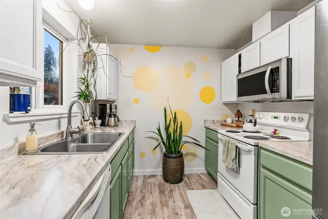 a kitchen with stainless steel appliances granite countertop a sink a stove and a wooden floors