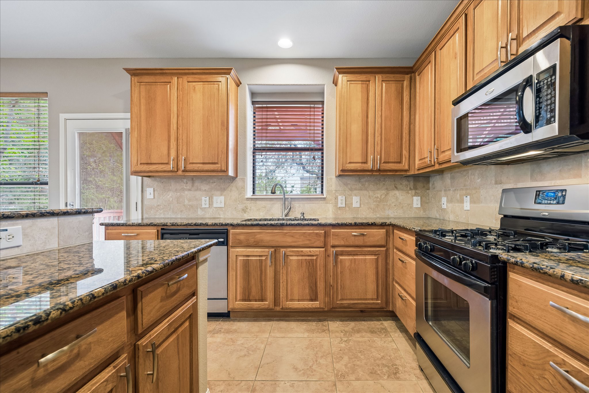 6705 Covered Bridge Drive, Unit 24 Austin, TX 78736 - Photo 11 of 31 a kitchen with stainless steel appliances granite countertop a stove sink and cabinets