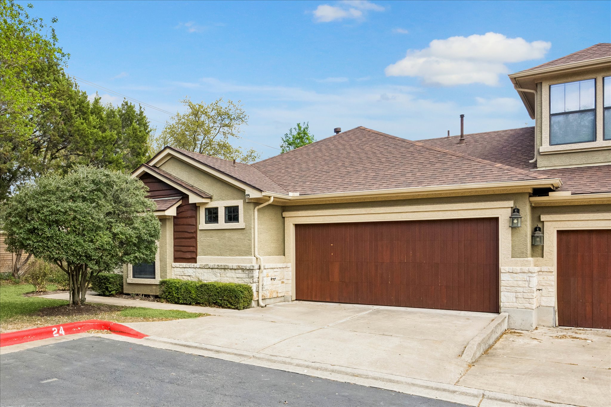 6705 Covered Bridge Drive, Unit 24 Austin, TX 78736 - Photo 2 of 31 a front view of a house with a yard and garage