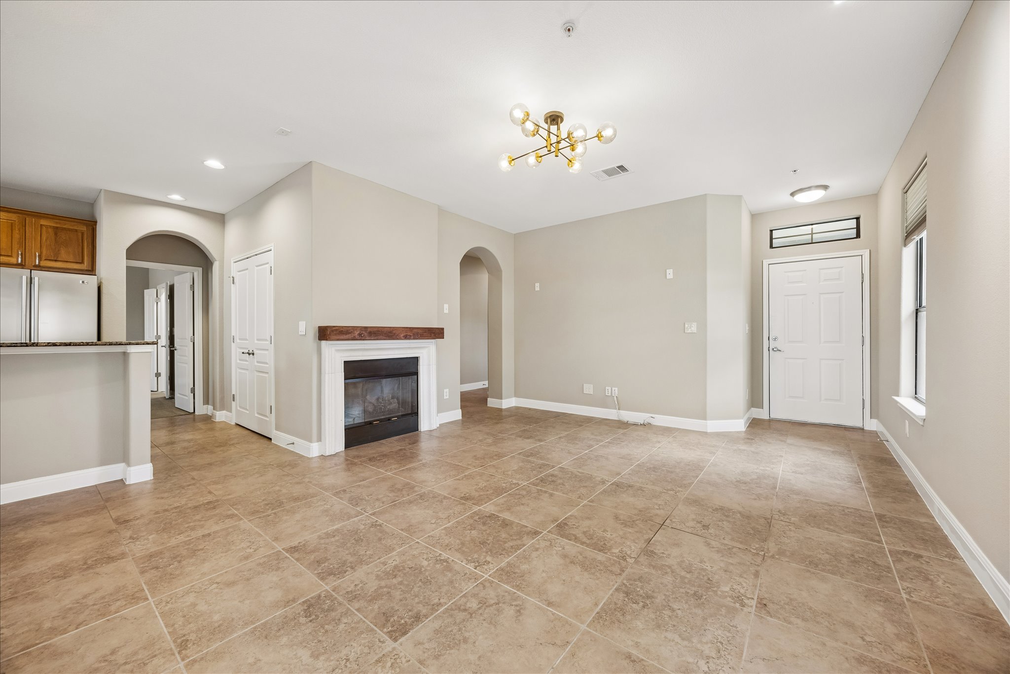 6705 Covered Bridge Drive, Unit 24 Austin, TX 78736 - Photo 7 of 31 an empty room with chandelier fan and fireplace