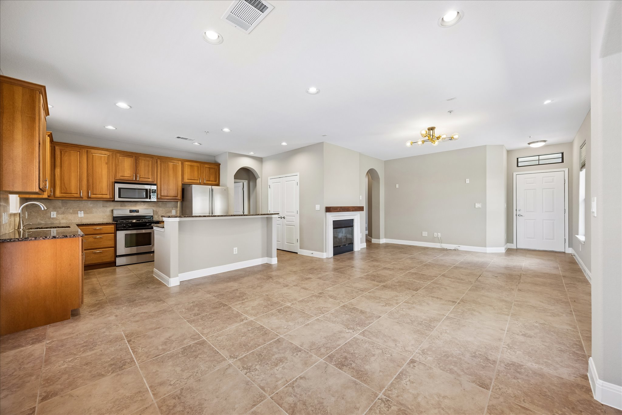 6705 Covered Bridge Drive, Unit 24 Austin, TX 78736 - Photo 9 of 31 a view of kitchen with kitchen island granite countertop a stove top oven a sink and a refrigerator