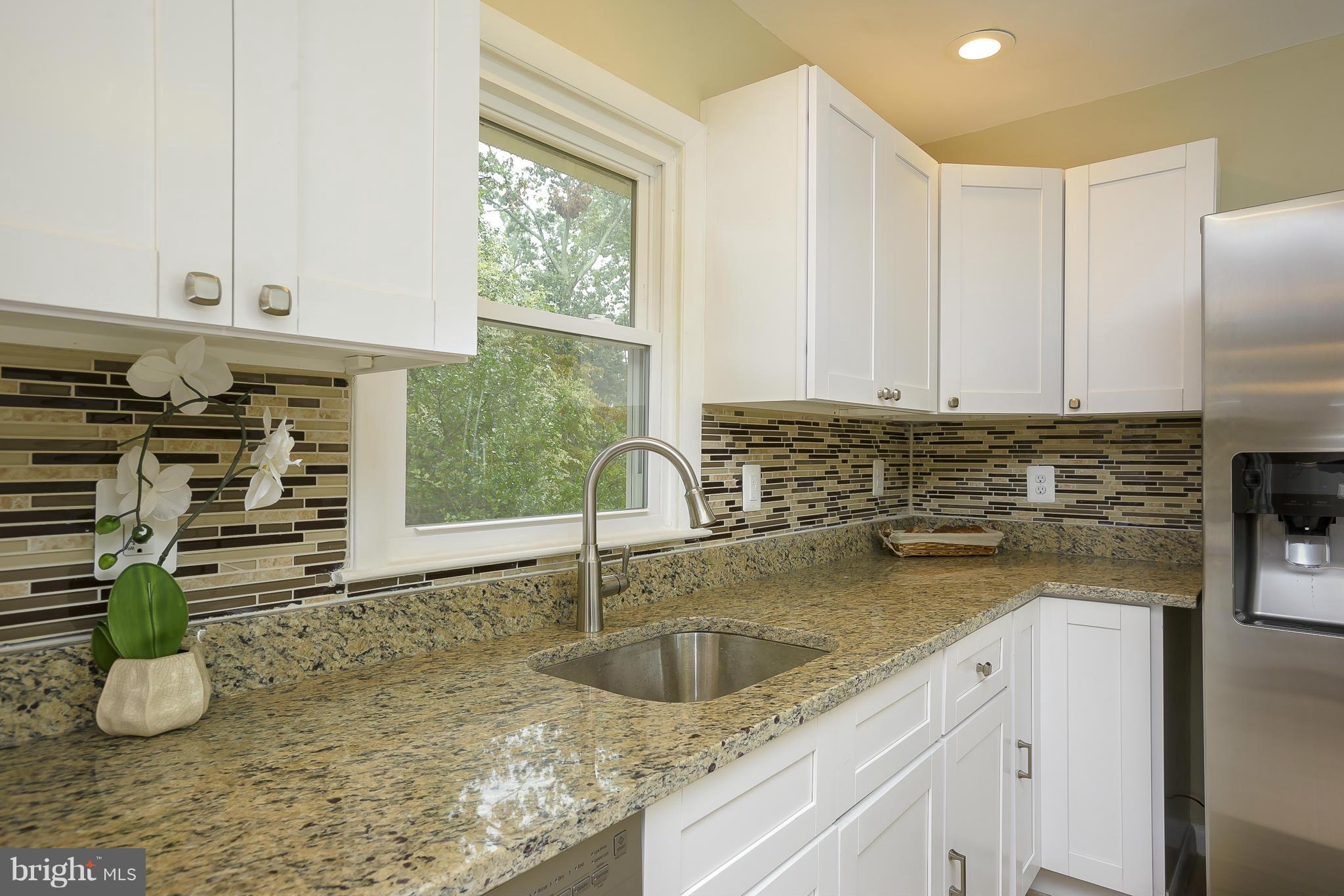 8413 Garland Road Pasadena, MD 21122 - Photo 11 of 30 a kitchen with granite countertop a sink a stove and a window